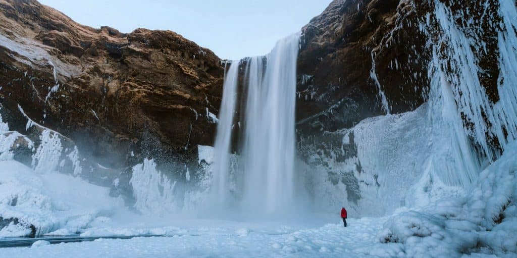 Islandia. Cascada con nieve con espectacular desnivel de tierra en Islandia