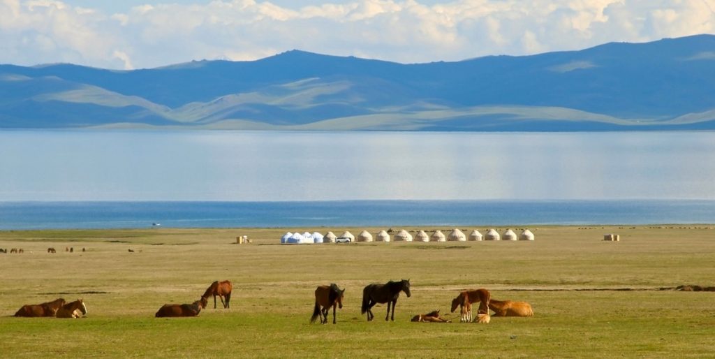Kirguistán. Vista de la vida nómada junto al lago con caballos y yurtas en Kirguistan