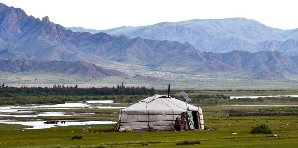 Mongolia. Tienda nómada (Ger) mongola montada en mitad del amplio paisaje, con ríos y mandas de caballos al fondo, en Mongolia